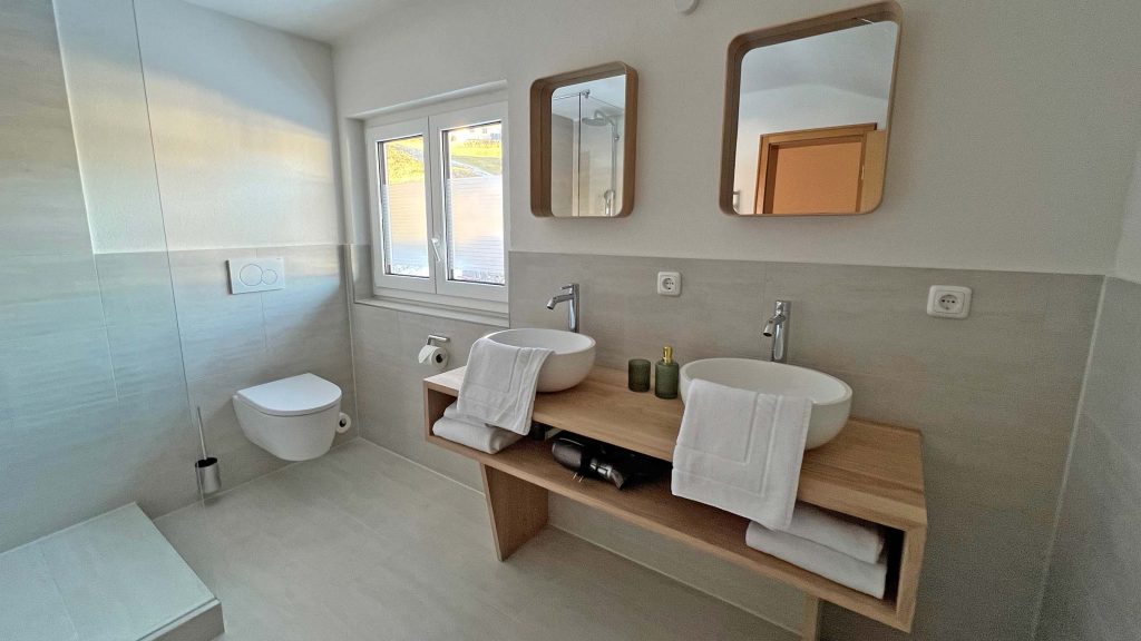 Badezimmer 2 mit Fenster, zwei Spiegeln und Doppelwaschbecken